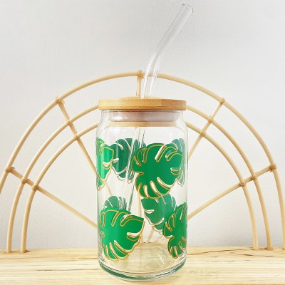 Glass tropical plant cup with green monstera plant leaves with a gold outline