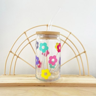 Beer can shaped retro daisies cup glass with multiple colors of retro daisies on the cup