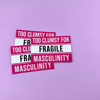 Hot Pink, White, and Black Sticker with text "TOO CLUMSY FOR FRAGILE MASCULINITY" in warning label format.