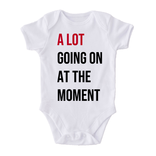 White baby onesie with A Lot Going On At The Moment text design in red and black